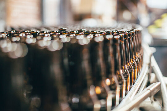 Close-up of beer bottles on machinery at brewery