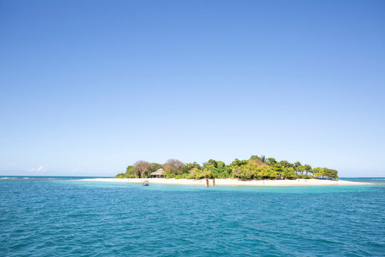 Island amidst sea against clear blue sky