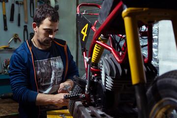 Mechanic repairing motorcycle at auto repair shop