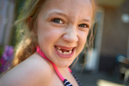 Close-up portrait of girl with gap toothed making face at backyard