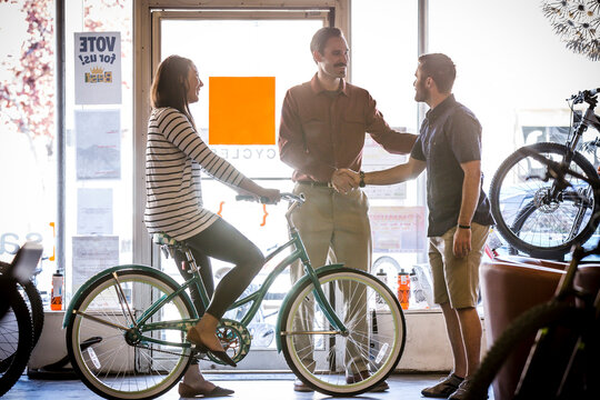 Owner talking to customers in bike shop