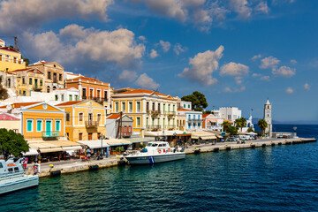 View on Symi (Simi) island harbor port, classical ship yachts, houses on island hills, Aegean Sea bay. Greece islands holidays vacation travel tours from Rhodos island. Symi, Greece,  Dodecanese.
