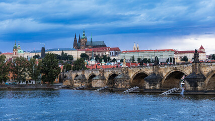 Fototapeta na wymiar Prague Castle, Charles Bridge and boats on the Vltava river. View of Hradcany Prague Castle, Charles Bridge and a boats on the Vltava river in the capital of the Czechia.