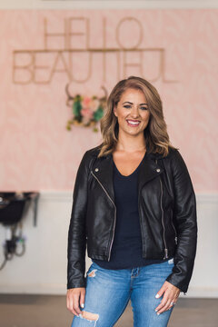 Portrait of confident smiling hairdresser standing in hair salon