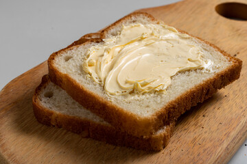 Toasted Loaf Bread with Margarine on a wood over the table