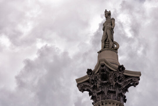 Low angle view of Nelson's Column against cloudy sky