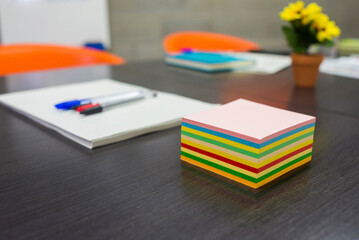 High angle view of colorful adhesive notes with pen and documents on conference table