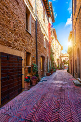 Cozy street decorated with colorful flowers, Pienza, Tuscany, Italy, Europe. Narrow street in the charming town of Pienza in Tuscany. Beautiful streets of the small and historic village Pienza, Italy