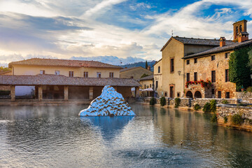 Fototapeta premium Thermal bath town of Bagno Vignoni, Italy during sunrise. Old thermal baths in the medieval village Bagno Vignoni, Tuscany, Italy. Medieval thermal baths in village Bagno Vignoni, Tuscany, Italy