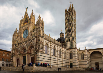 Fototapeta premium Famous Piazza del Duomo with historic Siena Cathedral, Tuscany, Italy. Siena Cathedral (Duomo di Siena) is a medieval church, now dedicated to the Assumption of Mary, Siena, Italy.