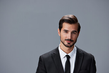Portrait of business man with phone conversation on gray background in business suit. Business portrait of a stylish man copy space