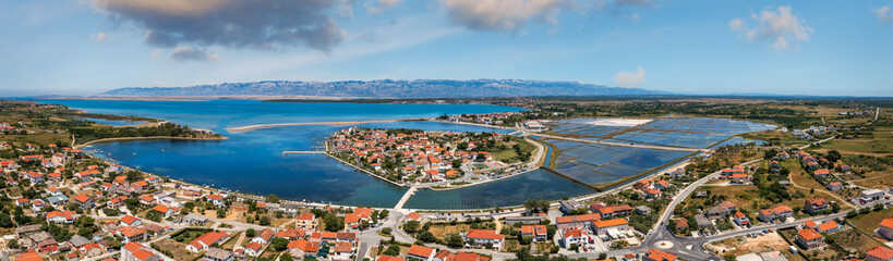 Naklejka na ściany i meble Historic town of Nin laguna aerial view with Velebit mountain background, Dalmatia region of Croatia. Aerial view of the famous Nin lagoon and medieval in Croatia
