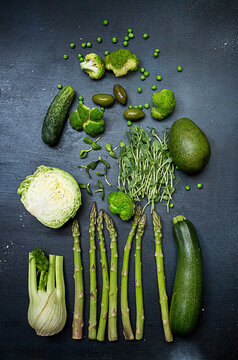 Flat lay of fresh green vegetables on black table