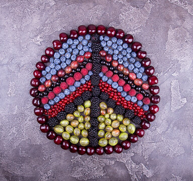 Overhead view of various fresh berries in peace symbol shape on table