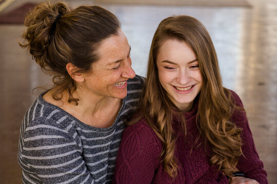 High angle view of happy mother and daughter sitting on floor at home