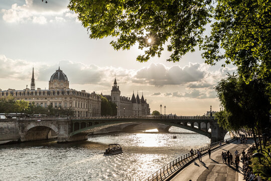 Pont Notre-Dame over Seine River against cloudy sky during sunset