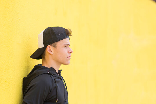 Side View Of Confident Man Looking Away Standing Against Yellow Wall In City