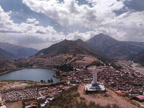 High angle view of Cristo Blanco statue on mountain against cloudy sky during sunny day