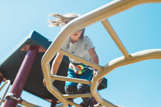 Child climbing on top of monkey bars on playground
