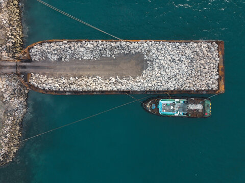 Aerial view of large barge with stones near Sumbawa island coastline
