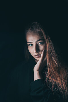 Young woman looking at the camera in dark studio