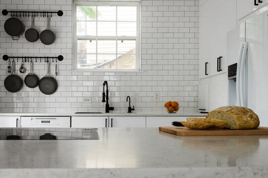 White Subway Tile Kitchen With Black Pans