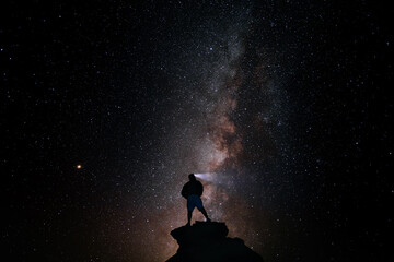 Silhouette of adventurous person looking at the milky way