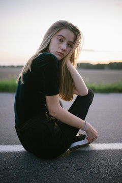 Woman sitting on the road in the countryside