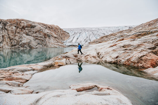 A Man Reflecting In A Pool By The The 'Twin Glacier'