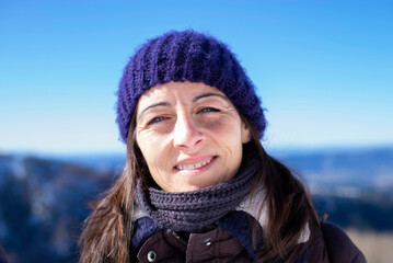 Closep up portrait of a smiling woman with blue hat in a sunny day
