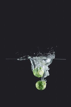 Brussels sprouts sprinkled water on dark background
