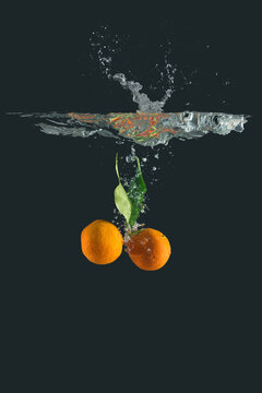 Mandarins immersed in water on black background