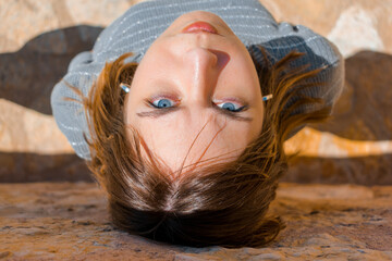 Upside-down portrait of a girl with blue eyes