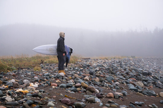 Young Man exploring Nova Scotia for a travel surf trip