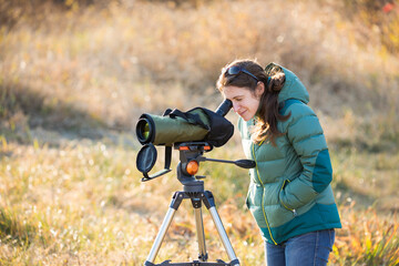 Young woman bird watching with spotting scope