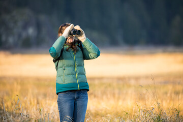 Young woman bird watching with binoculars
