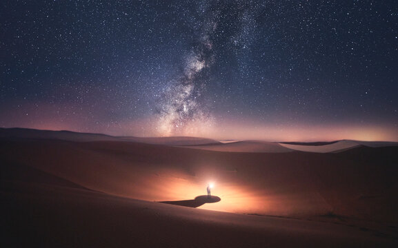 Morocco, Desert of Erg Chebbi, silhouette of man looking at milky way