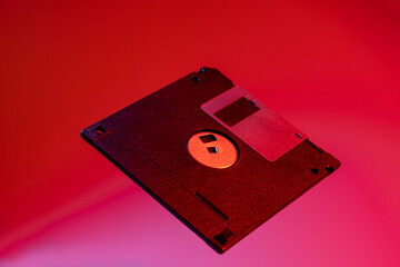 Old aged floppy disk on background with vibrant colors