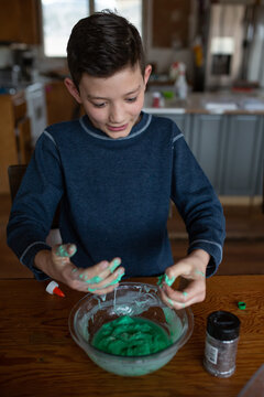 Boy mixing up homemade slime with his hands