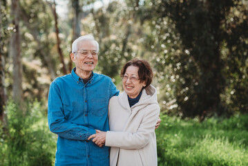 Portrait of senior active couple embracing outside
