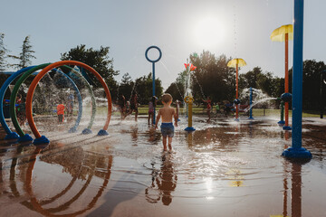 Toddler boy walking on splash pad water park