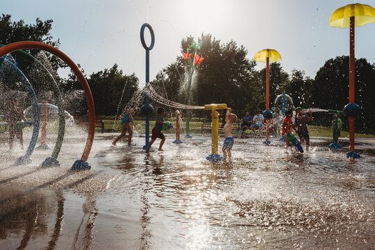 Toddler boy playing with water toy at splash pad