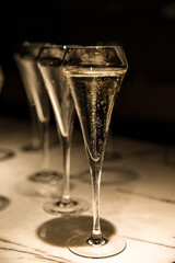 set of champagne glasses on table top (golden light bubbly fine wining in a restaurant)