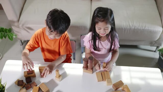 Children boy and girl playing with constructor wooden block building, Happy little kids play wood block stacking board game at home, activities learning creative, toys for preschool and kindergarten