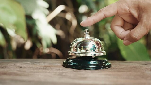 Hospitality hotel. Customer hand ringing service bell at coffee cafe shop for calling the staff to receive the menu, Woman finger touching to ring bell