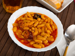 Traditional Asturian rich beans stew Fabada with pork shoulder, morcilla and chorizo served in...