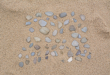 Fototapeta na wymiar Many stones on wet sand, top view