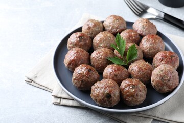 Tasty cooked meatballs with parsley served on light grey table