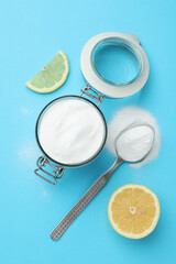 Baking soda and lemon on blue background, flat lay