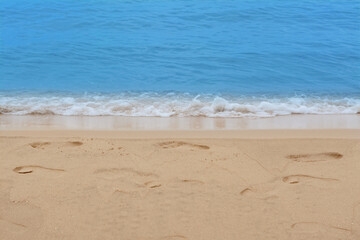 Fototapeta na wymiar Sandy beach with footprints near beautiful sea